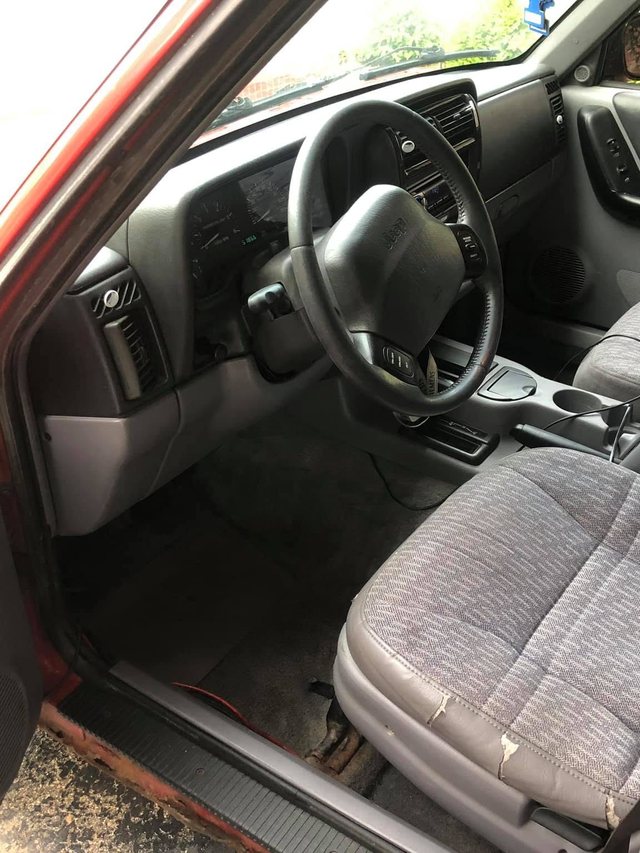 The same driver area after the interior detail — seat, carpet, door sill and dash all clean.