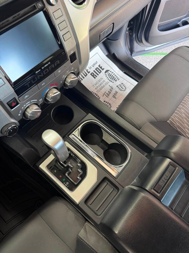 The same truck console and cup holders after cleaning — trays and cup holders clear, with a Huff Auto Detailing thank-you card resting on the seat.
